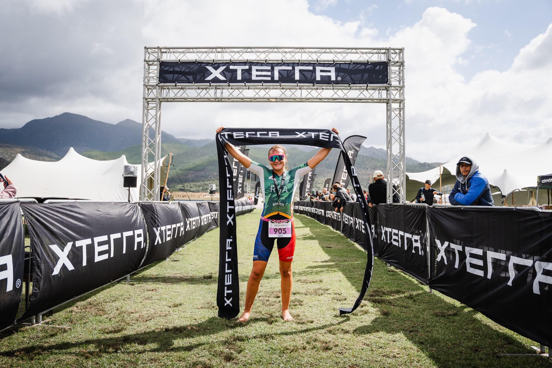 Young XTERRA athlete celebrating with the finish-line ribbon raised overhead